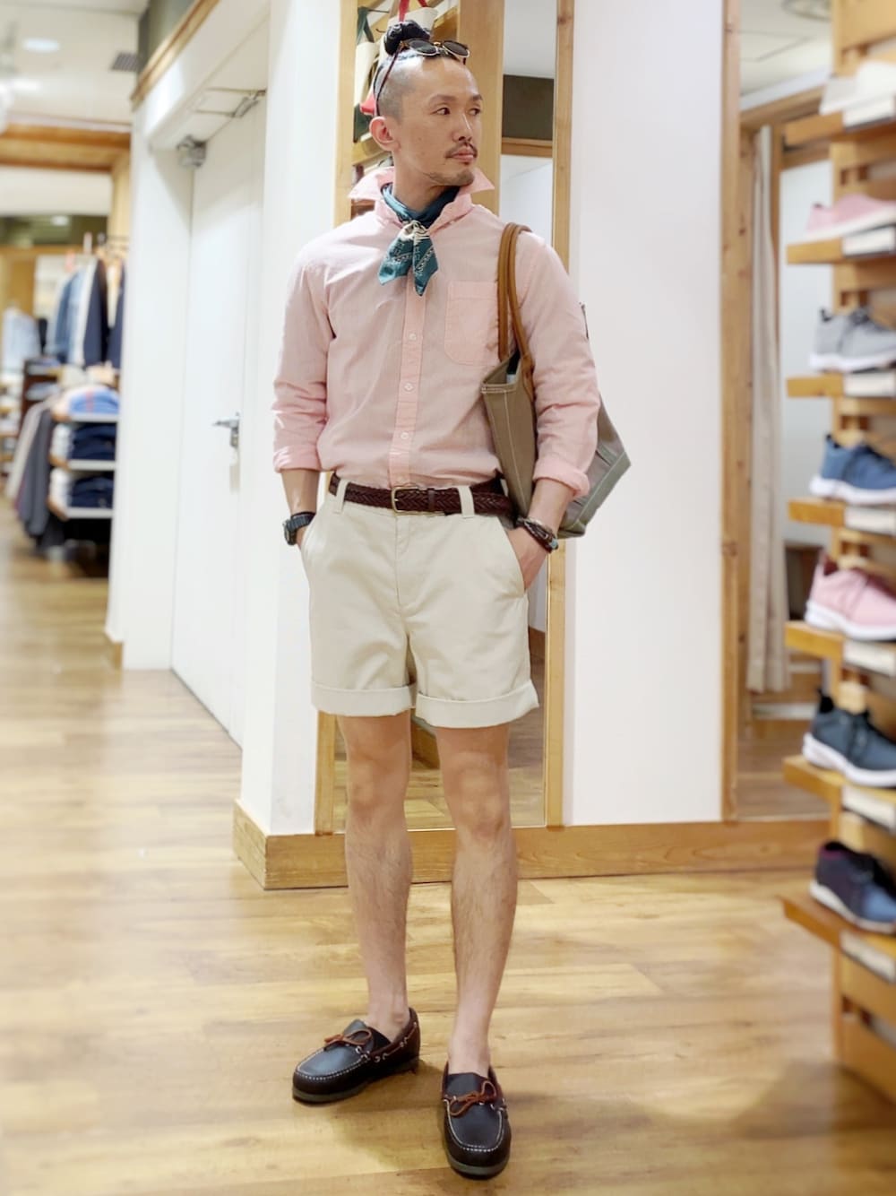ベージュ系のパンツ、ブラウン系のモカシン/デッキシューズ、ブルー系のトートバッグを着用したメンズの夏コーディネートの1枚目の写真