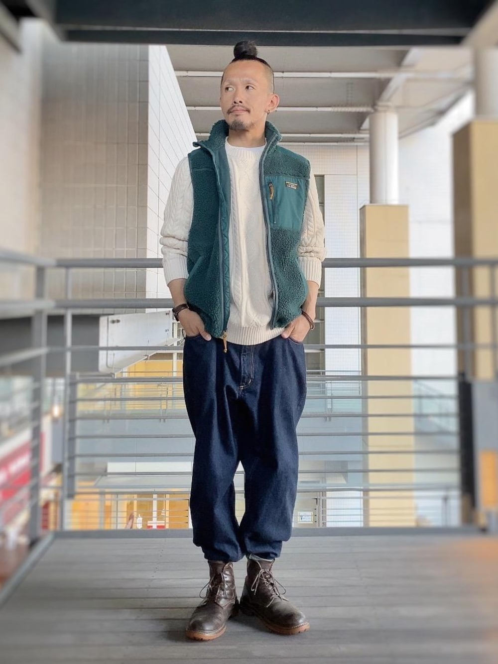 ベージュ系のニット/セーター、グリーン系のベストを着用したメンズの秋コーディネートの1枚目の写真