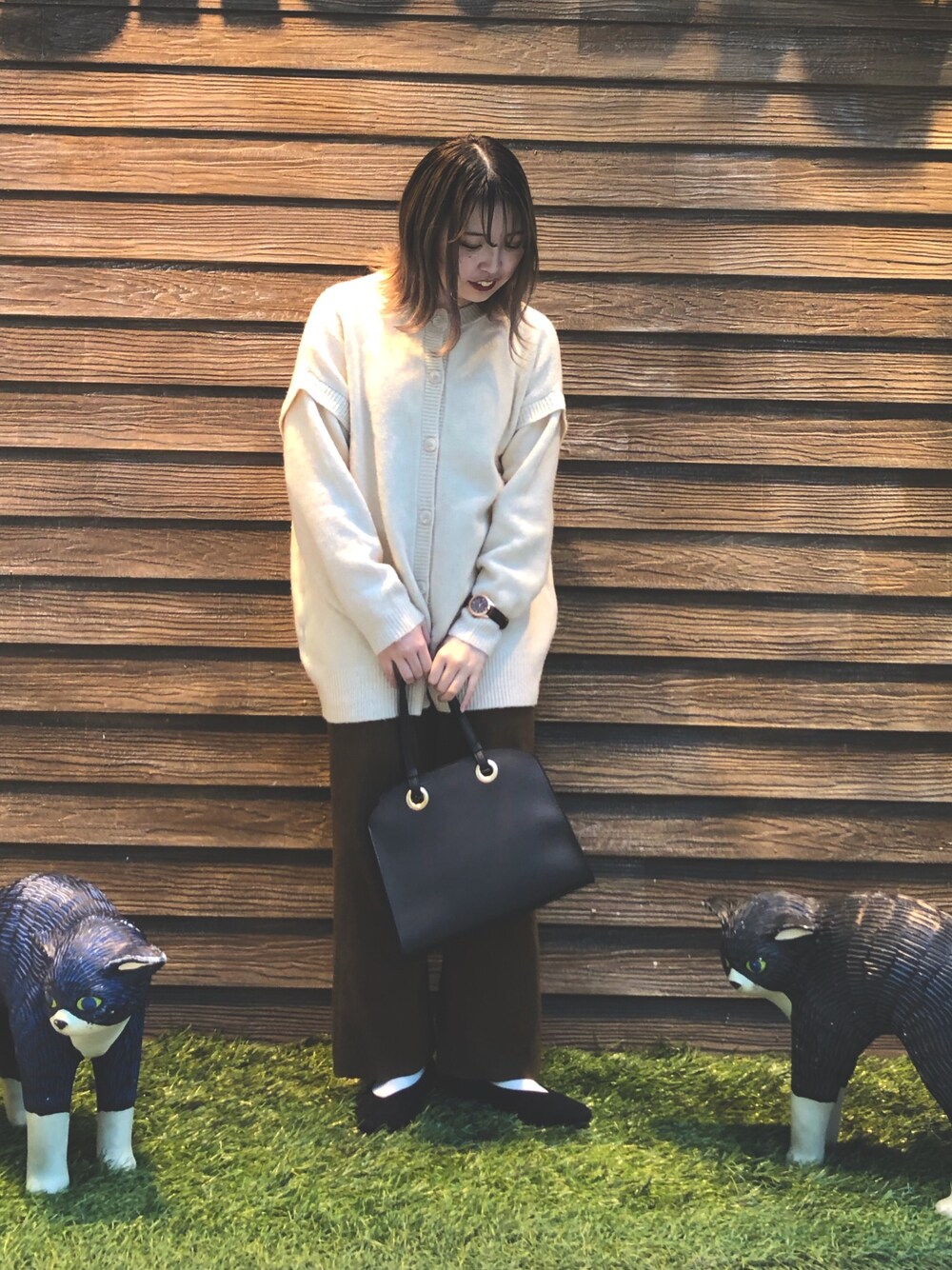 ホワイト系のニット/セーター、ブラウン系のその他パンツ、ブラック系のトートバッグを着用したレディースの秋コーディネートの1枚目の写真