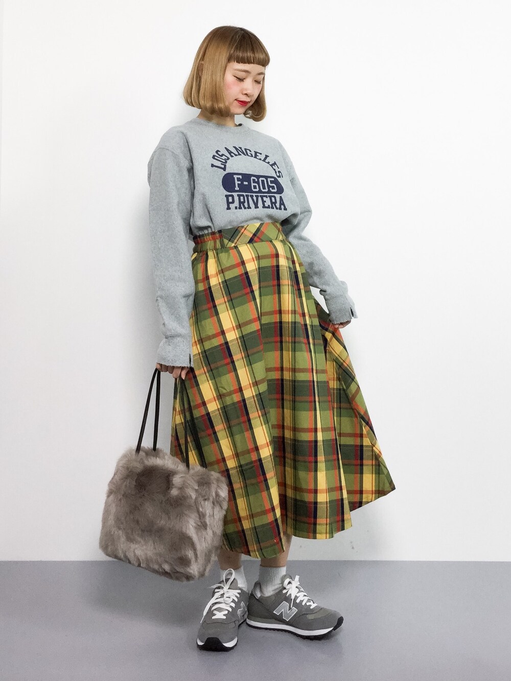 ベージュ系のトートバッグ、イエロー系のスカート、グレー系のスウェットを着用したレディースの秋コーディネートの1枚目の写真