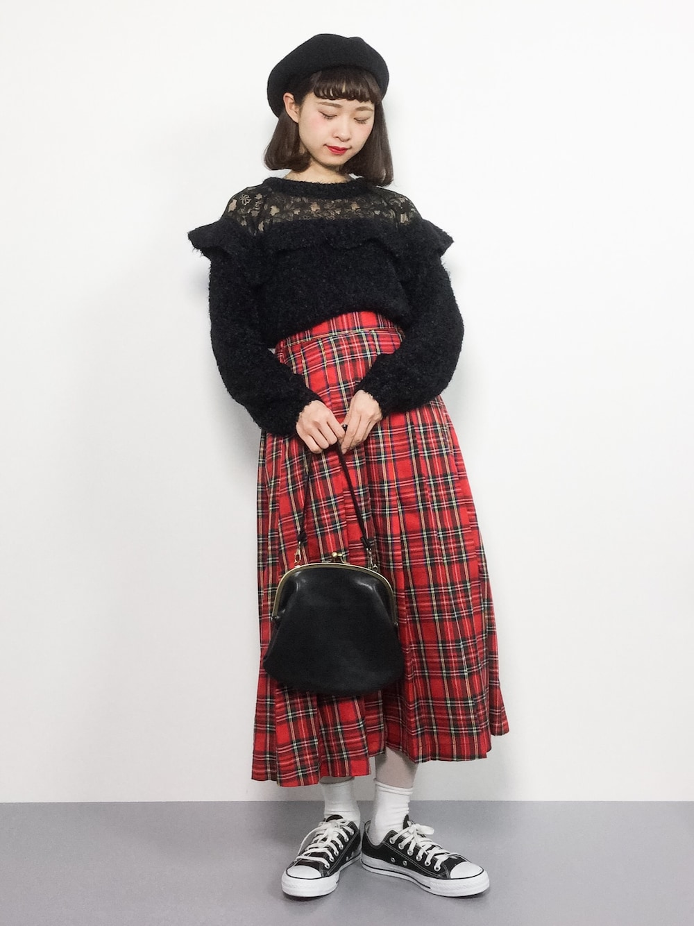 ブラック系のニット/セーター、レッド系のスカート、ブラック系のハンドバッグを着用したレディースの冬コーディネートの1枚目の写真