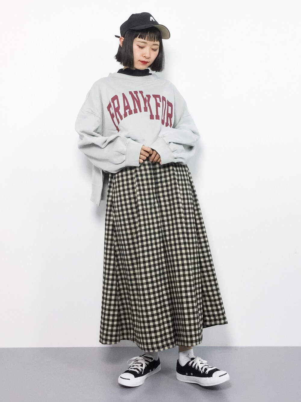 グレー系のTシャツ/カットソー、ブラック系のスカートを着用したレディースの冬コーディネートの1枚目の写真