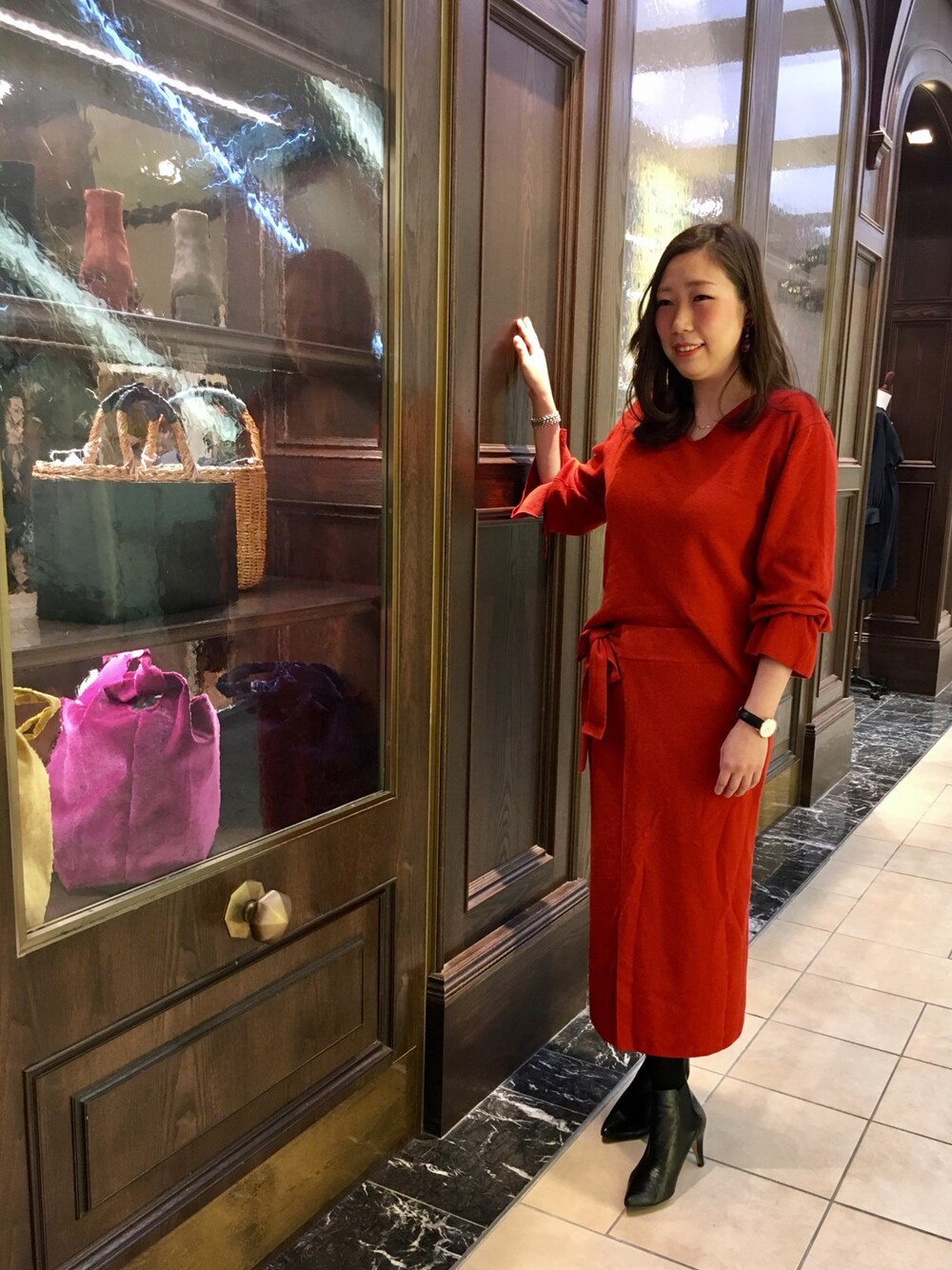 オレンジ系のニット/セーター、オレンジ系のスカートを着用したレディースの冬コーディネートの1枚目の写真