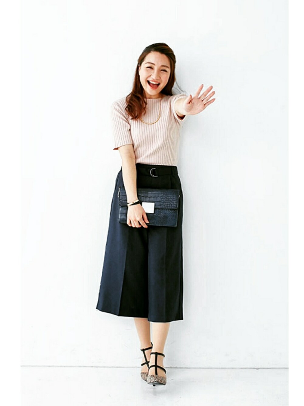 ピンク系のトップス、ブラック系のパンツを着用したレディースの秋コーディネートの1枚目の写真