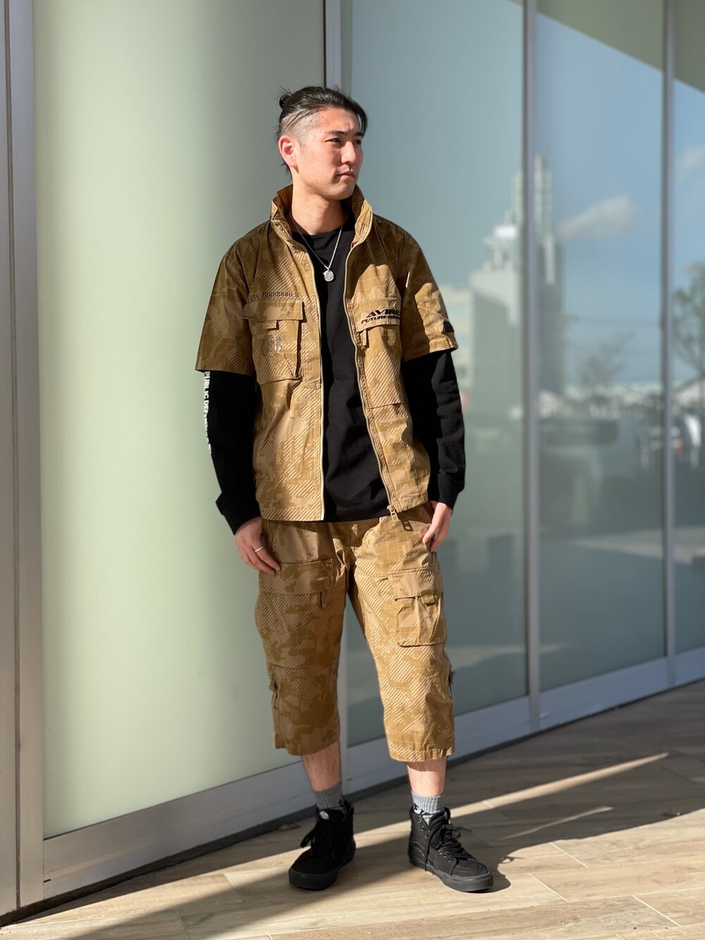 ブラウン系のシャツ/ブラウス、ブラック系のTシャツ/カットソー、ブラウン系のカーゴパンツを着用したメンズの春コーディネートの1枚目の写真