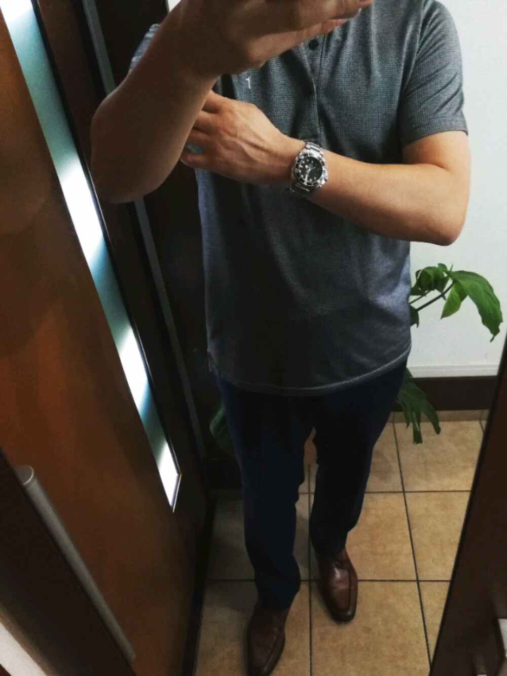 シルバー系のポロシャツ、ブラウン系のドレスシューズ、ブラック系のアナログ腕時計を着用したメンズの夏コーディネートの1枚目の写真