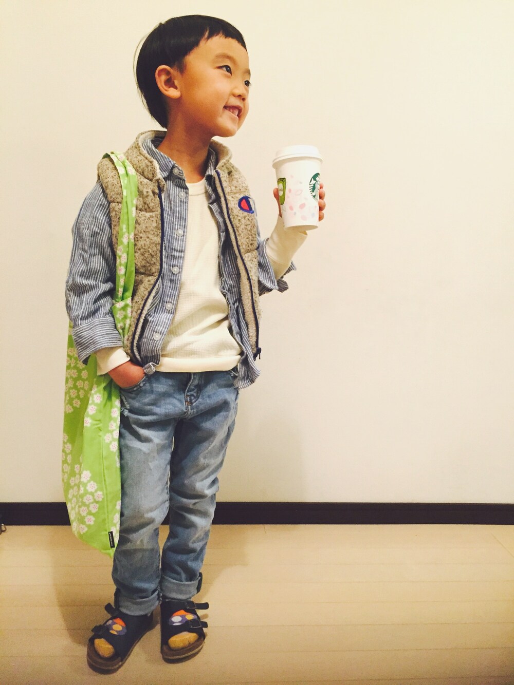 ホワイト系のダウンベスト、ブルー系のシャツ/ブラウス、ホワイト系のTシャツ/カットソーを着用したキッズの冬コーディネートの1枚目の写真