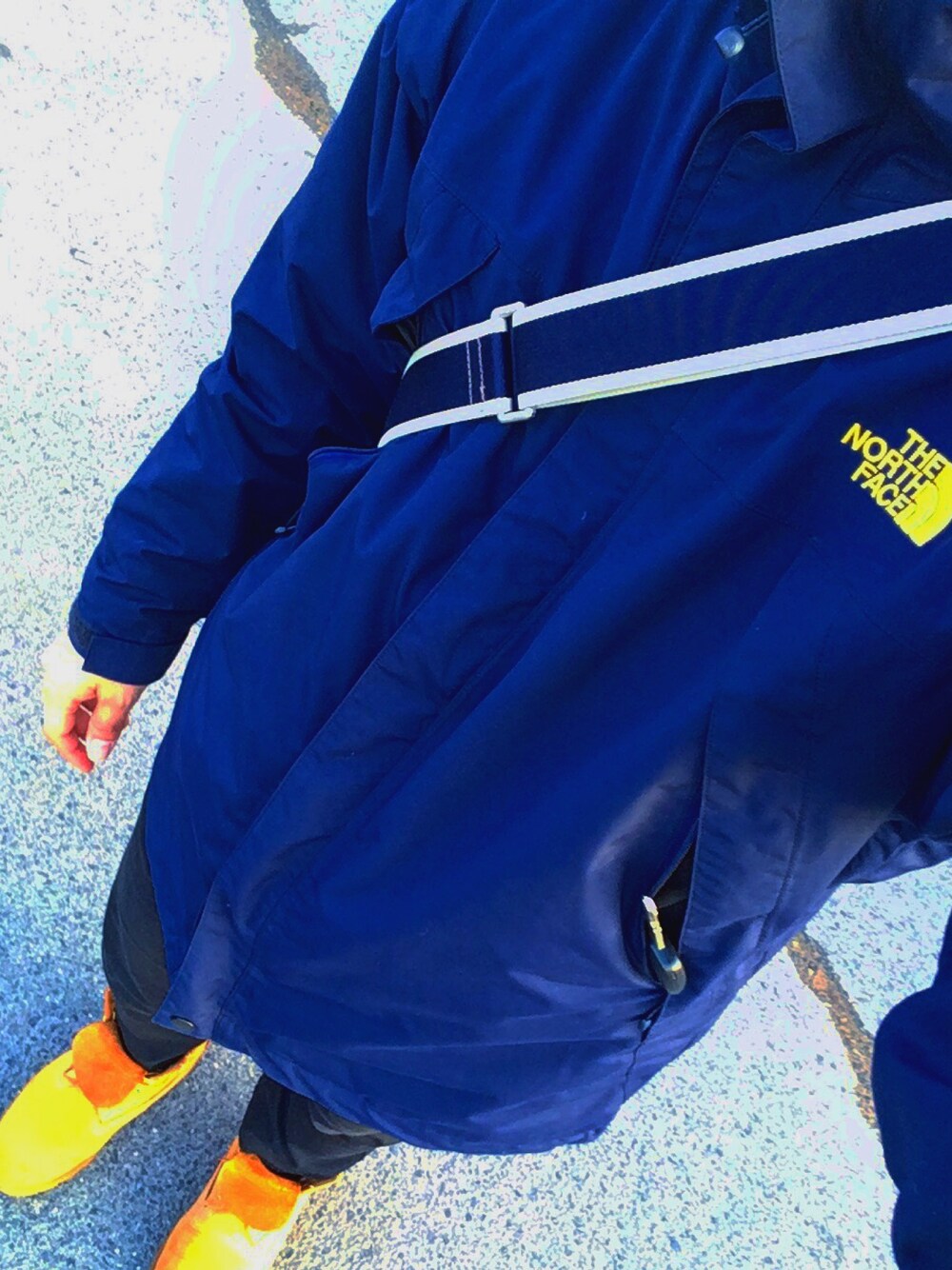 ブルー系のマウンテンパーカー、ベージュ系のブーツ、ブラウン系のショルダーバッグを着用したメンズの冬コーディネートの1枚目の写真