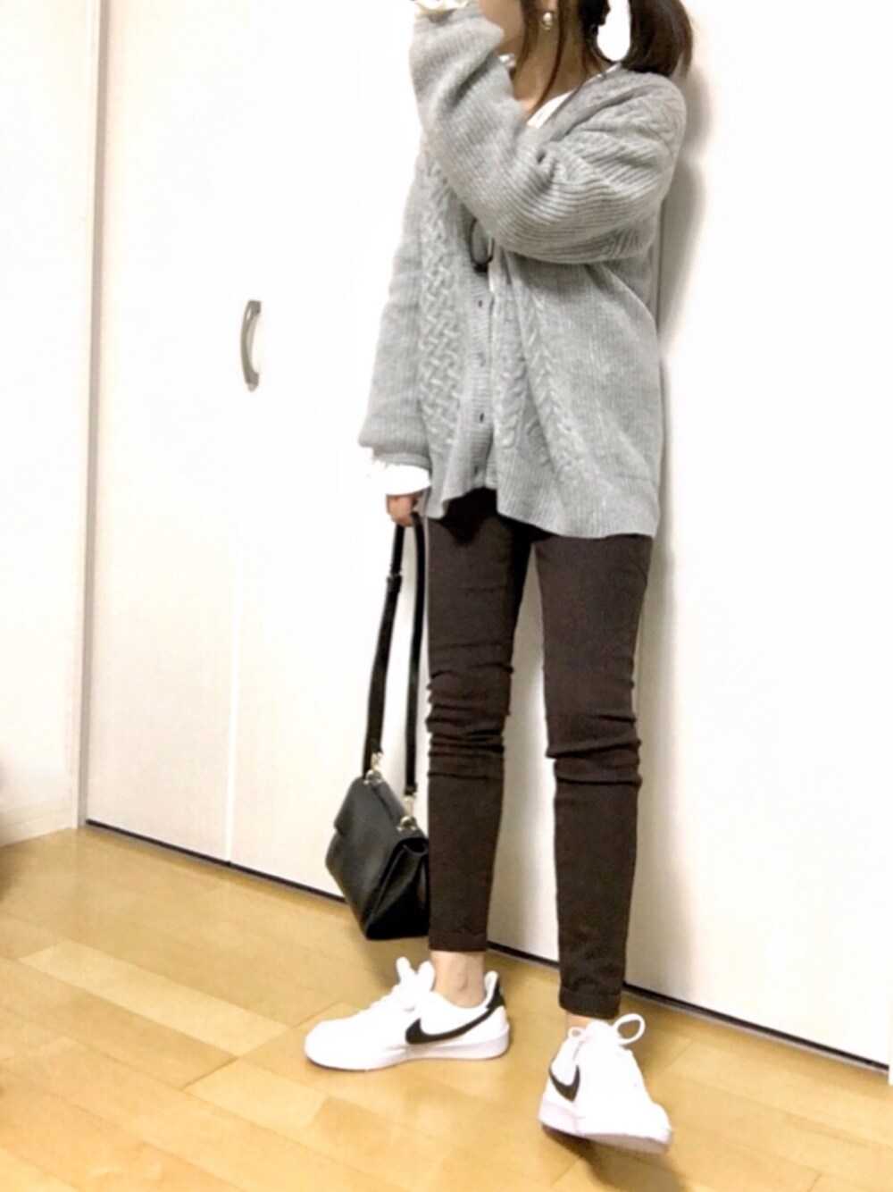 グレー系のカーディガン/ボレロ、ブラウン系のその他パンツ、ホワイト系のニット/セーターを着用したレディースの冬コーディネートの1枚目の写真