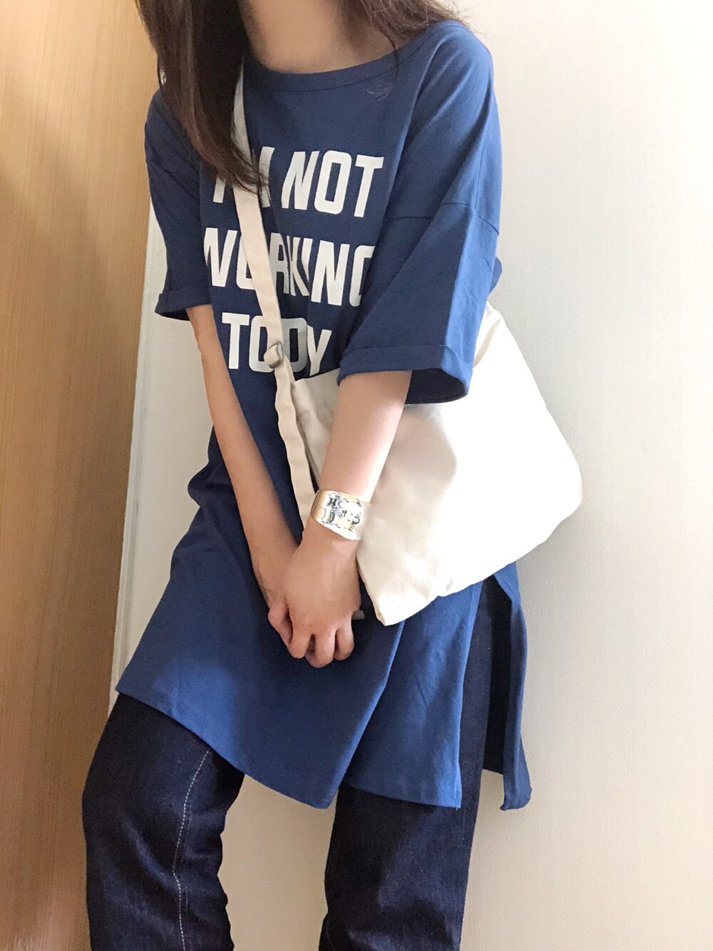 ブルー系のワンピース、ブルー系のデニムパンツ、レッド系のショルダーバッグを着用したレディースの春コーディネートの1枚目の写真