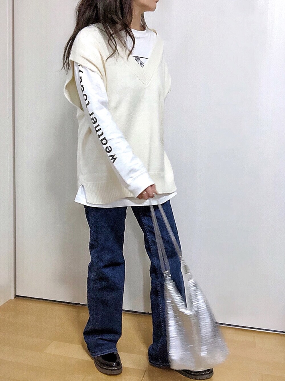 ホワイト系のベスト、ホワイト系のTシャツ/カットソー、ブルー系のデニムパンツを着用したレディースの春コーディネートの1枚目の写真