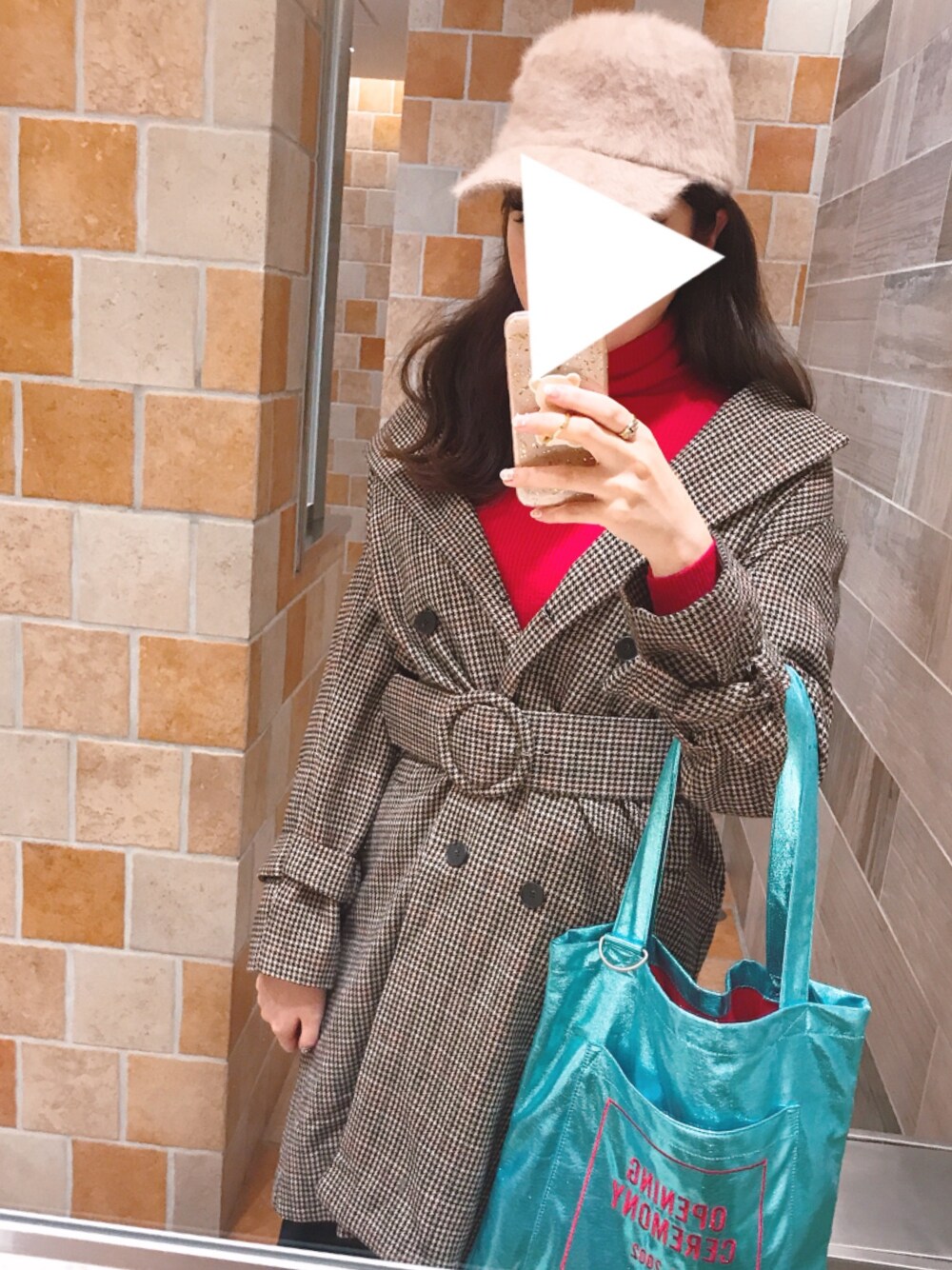 ブラウン系のチェスターコート、ブルー系のトートバッグ、レッド系のニット/セーターを着用したレディースの冬コーディネートの1枚目の写真