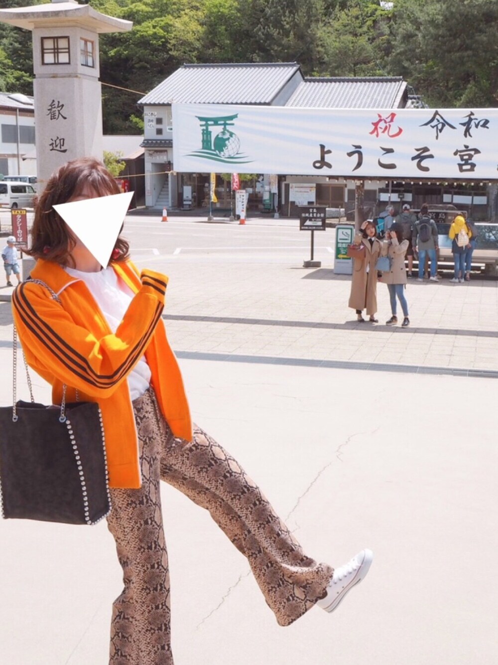 オレンジ系のジャージ、ブラウン系のパンツ、ホワイト系のスニーカーを着用したレディースの春コーディネートの1枚目の写真