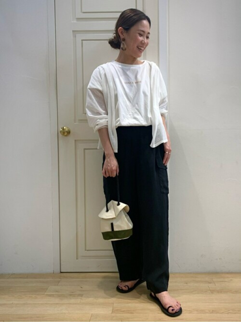 ホワイト系のニット/セーター、ホワイト系のTシャツ/カットソー、ブラック系のその他パンツを着用したレディースの夏コーディネートの1枚目の写真