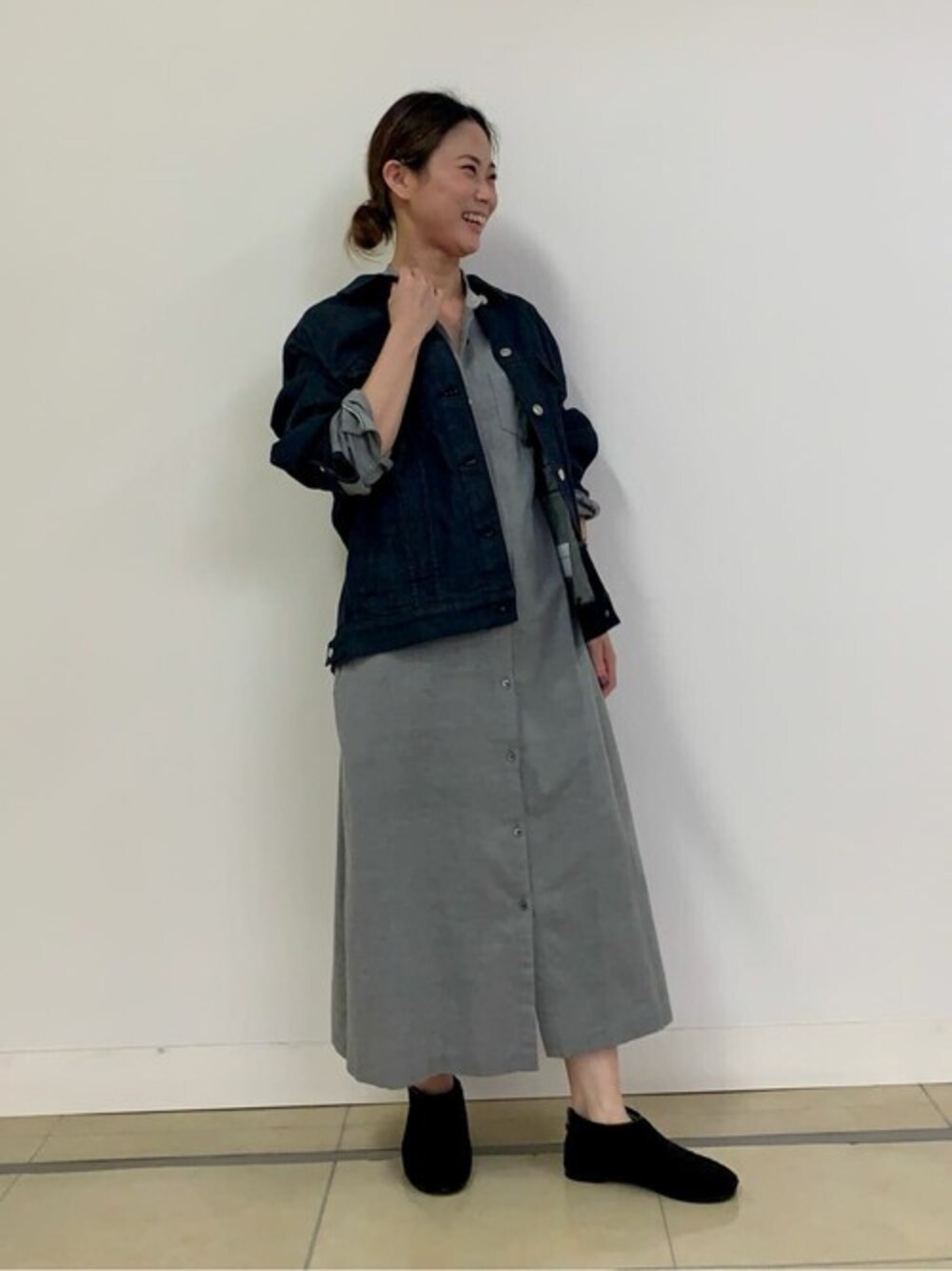 グレー系のワンピース、ブルー系のブルゾン、ブラック系のスリッポンを着用したレディースの秋コーディネートの1枚目の写真