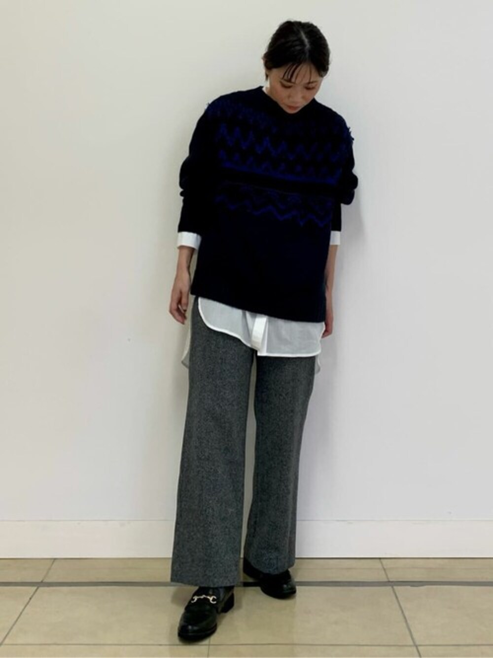 ブルー系のニット/セーター、ホワイト系のシャツ/ブラウス、ブラック系のその他パンツを着用したレディースの秋コーディネートの1枚目の写真