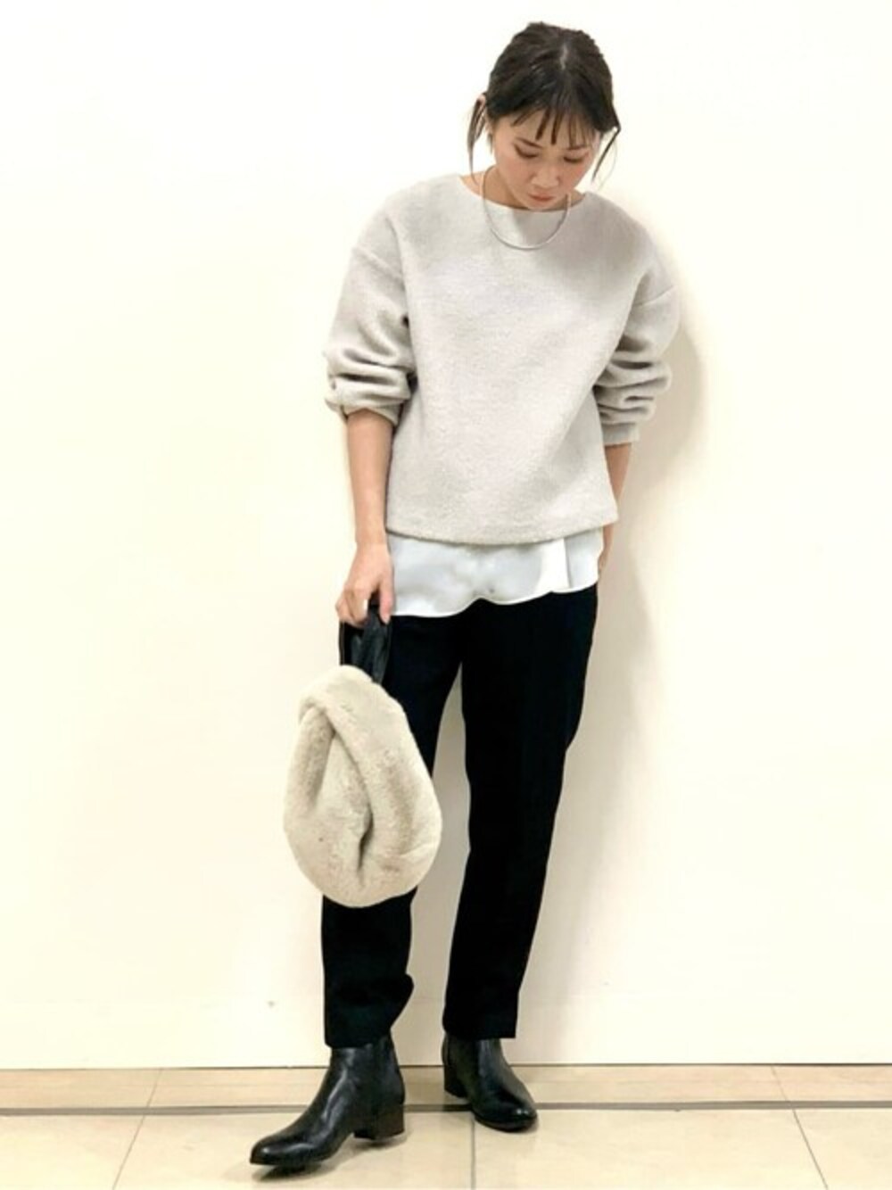 イエロー系のTシャツ/カットソー、ブラック系のその他パンツ、ホワイト系のハンドバッグを着用したレディースの冬コーディネートの1枚目の写真