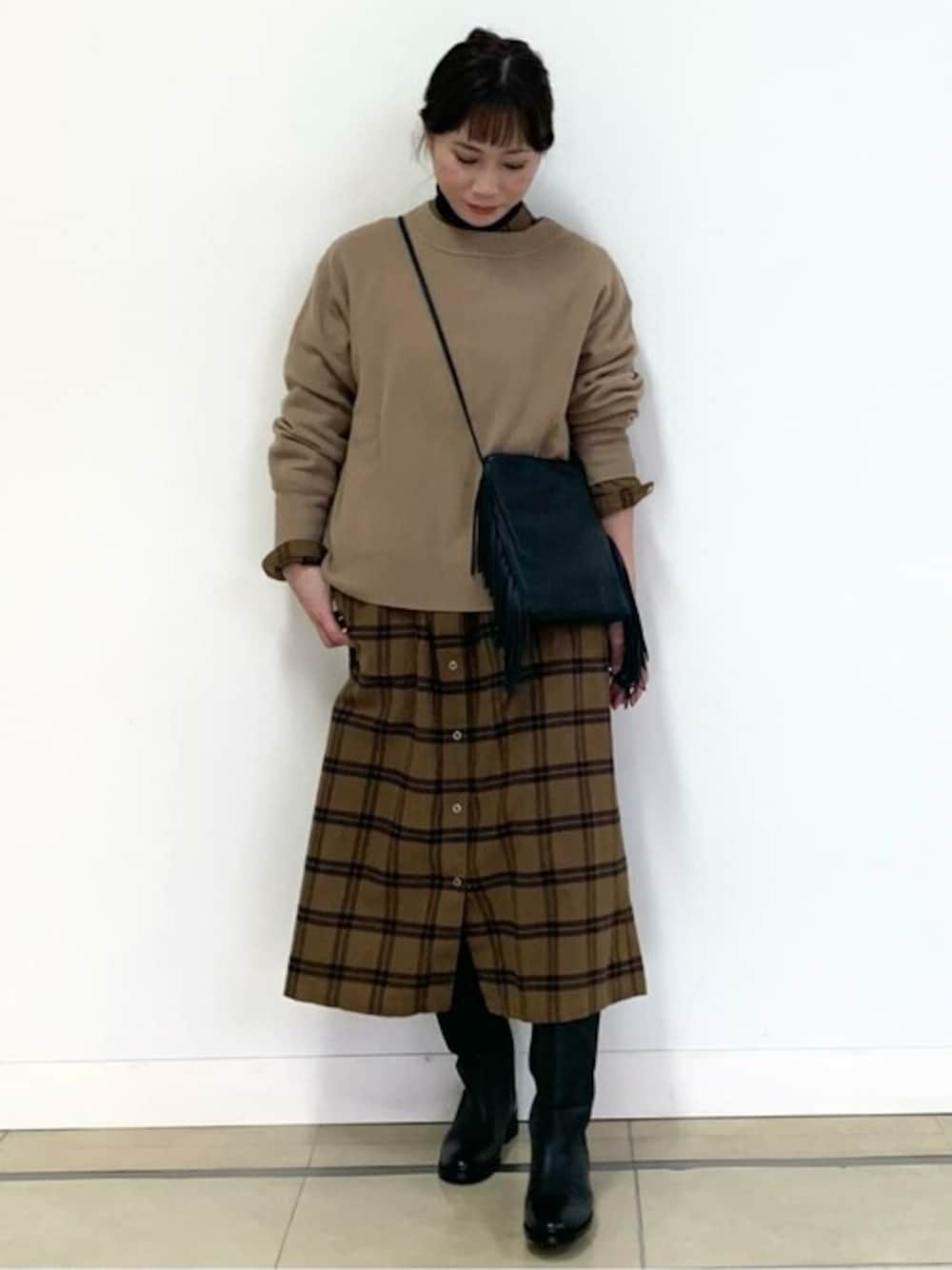 ベージュ系のニット/セーター、イエロー系のシャツワンピース、グレー系のTシャツ/カットソーを着用したレディースの冬コーディネートの1枚目の写真