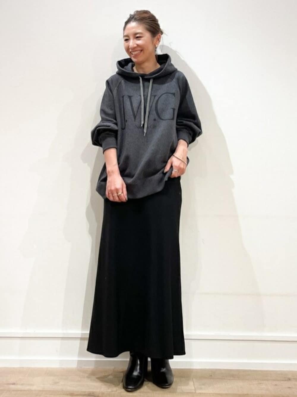 ブラック系のスカート、グレー系のパーカーを着用したレディースの冬コーディネートの1枚目の写真