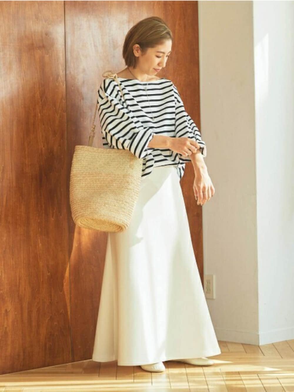 ホワイト系のスカート、ホワイト系のTシャツ/カットソーを着用したレディースの冬コーディネートの1枚目の写真