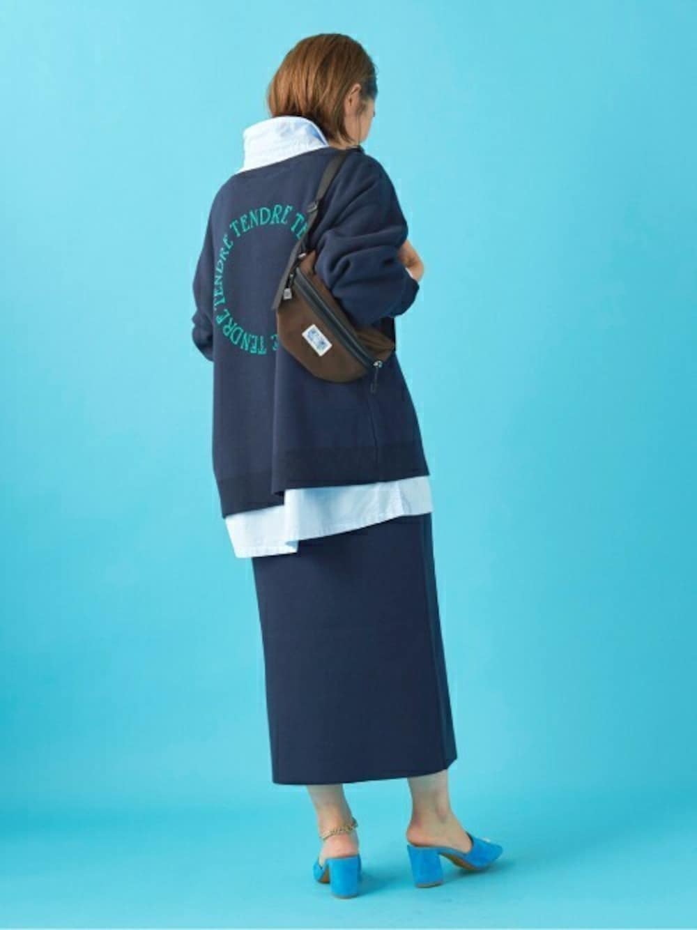 ブラウン系のボディバッグ/ウエストポーチ、ブルー系のニット/セーター、ブルー系のスカートを着用したレディースの冬コーディネートの1枚目の写真