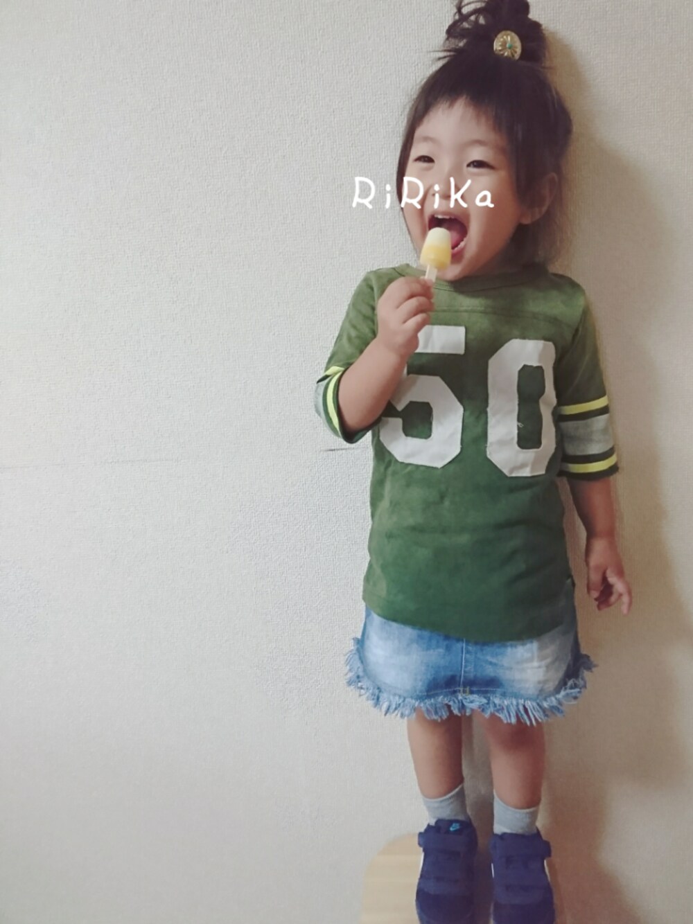 グリーン系のTシャツ/カットソー、ブルー系のデニムスカート、ブルー系のスニーカーを着用したキッズの春コーディネートの1枚目の写真