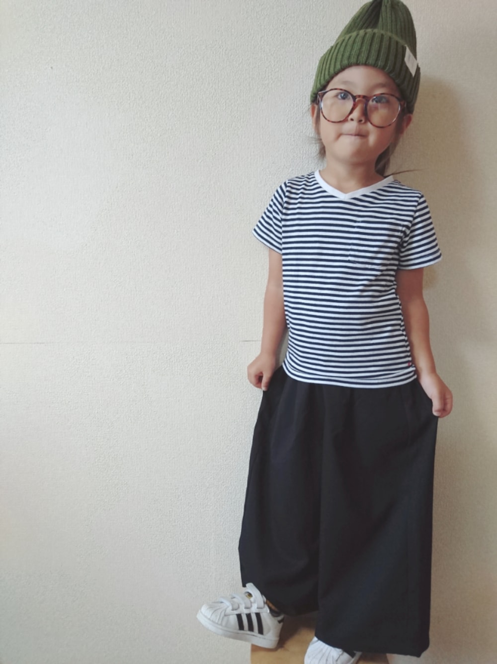 ブルー系のTシャツ/カットソー、ホワイト系のスニーカー、グリーン系のニットキャップ/ビーニーを着用したキッズの秋コーディネートの1枚目の写真