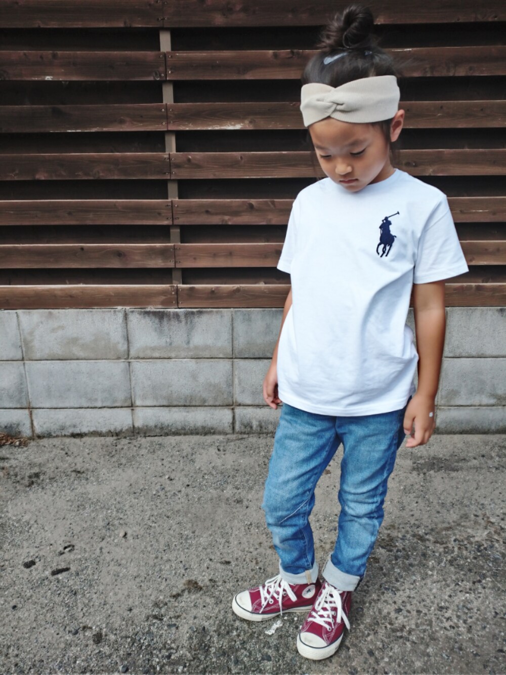 レッド系のスニーカー、ホワイト系のTシャツ/カットソー、ベージュ系のヘアバンドを着用したキッズの秋コーディネートの1枚目の写真