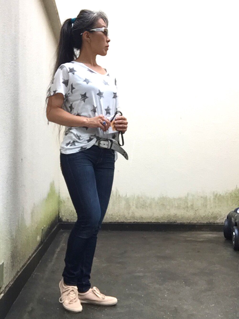 ブルー系のデニムパンツ、ベージュ系のスニーカー、ホワイト系のTシャツ/カットソーを着用したレディースの夏コーディネートの1枚目の写真