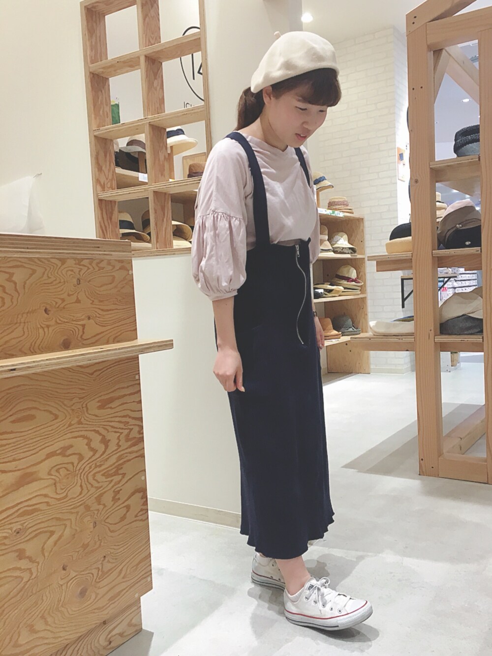 ピンク系のTシャツ/カットソー、ブルー系のジャンパースカート、ホワイト系のスニーカーを着用したレディースの春コーディネートの1枚目の写真