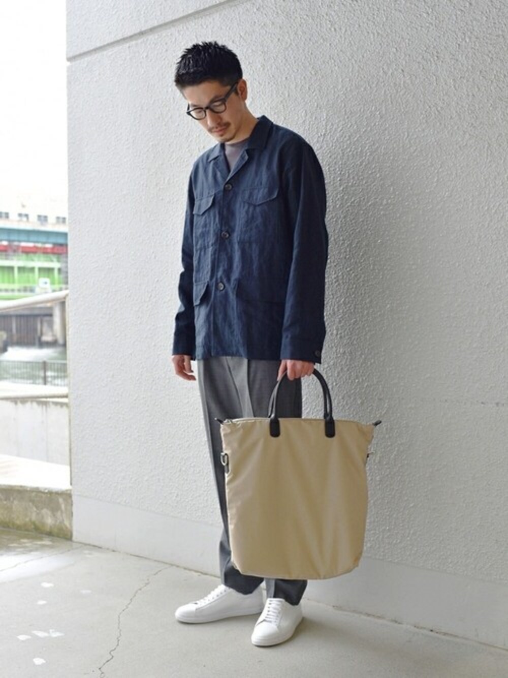 グレー系のTシャツ/カットソー、グレー系のスラックス、ホワイト系のスニーカーを着用したメンズの春コーディネートの1枚目の写真