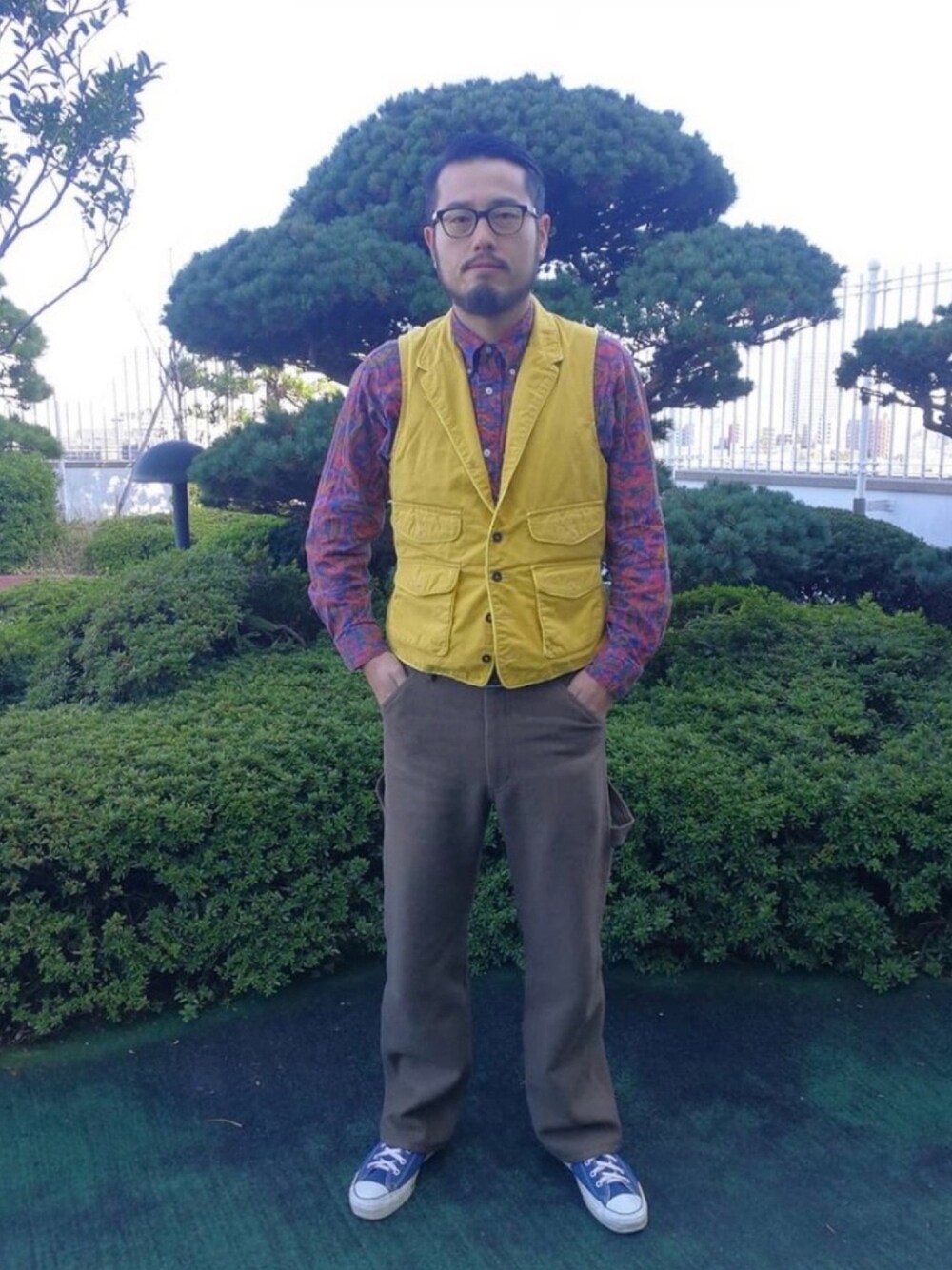 イエロー系のベスト、レッド系のシャツ/ブラウス、グリーン系のその他パンツを着用したメンズの冬コーディネートの1枚目の写真