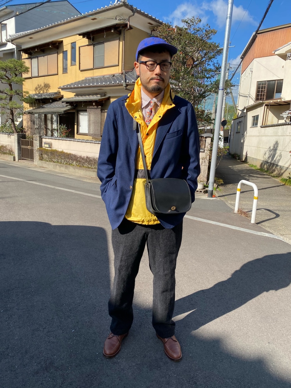 レッド系のネクタイ、イエロー系のパーカー、ブルー系のテーラードジャケットを着用したメンズの春コーディネートの1枚目の写真