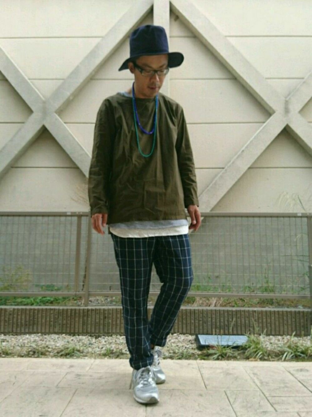 グリーン系のシャツ/ブラウス、シルバー系のスニーカー、ホワイト系のタンクトップを着用したメンズの秋コーディネートの1枚目の写真