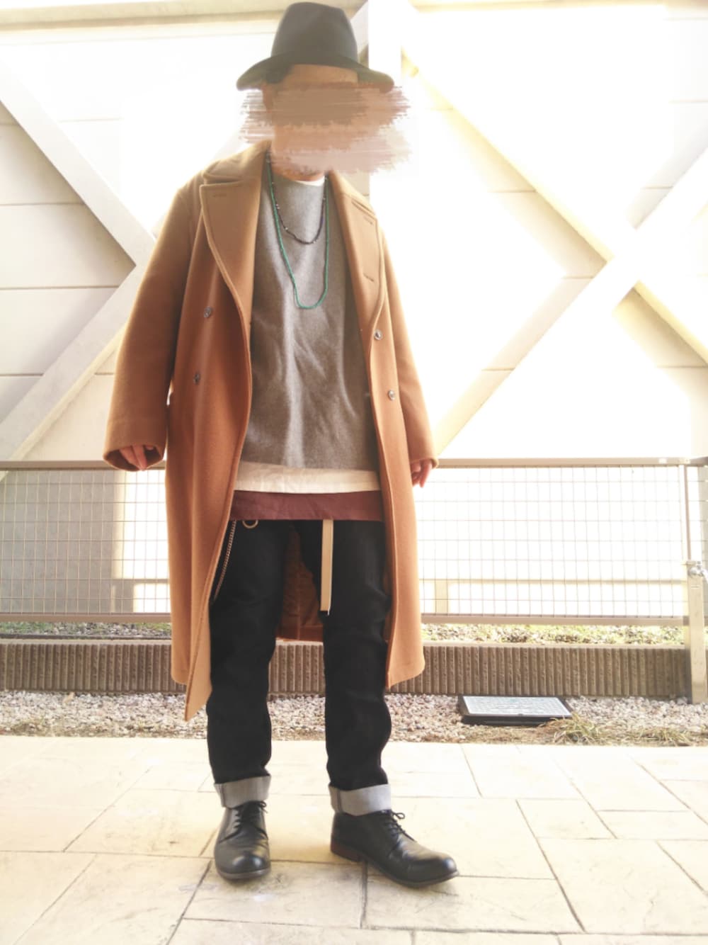 グレー系のニット/セーター、イエロー系のチェスターコート、ホワイト系のTシャツ/カットソーを着用したメンズの冬コーディネートの1枚目の写真