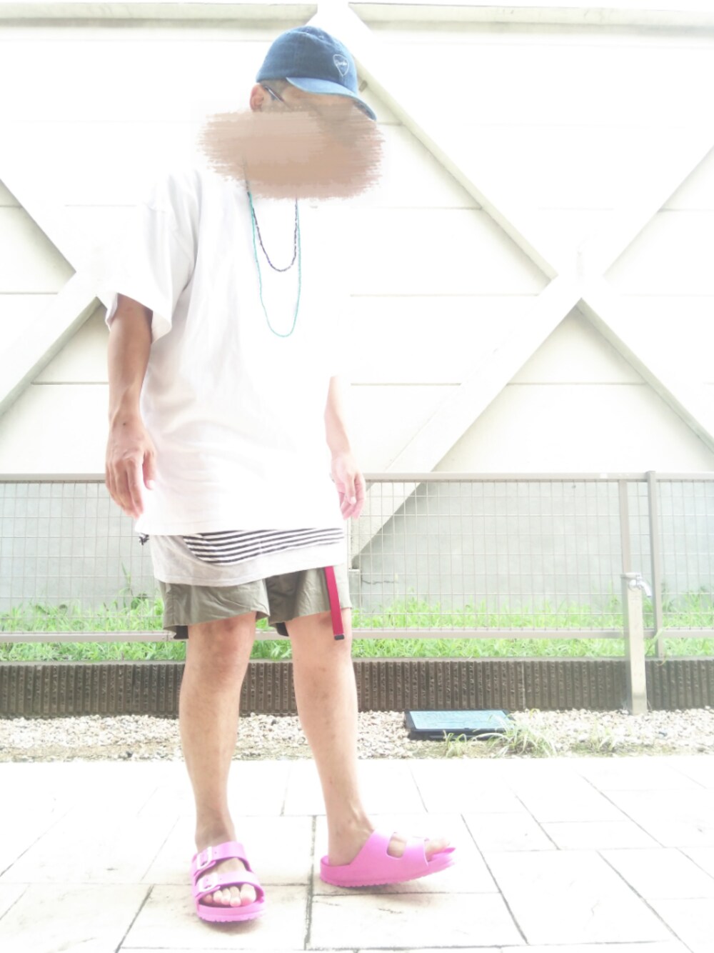 グレー系のタンクトップ、グリーン系のチノパンツ、ブラック系のTシャツ/カットソーを着用したメンズの夏コーディネートの1枚目の写真