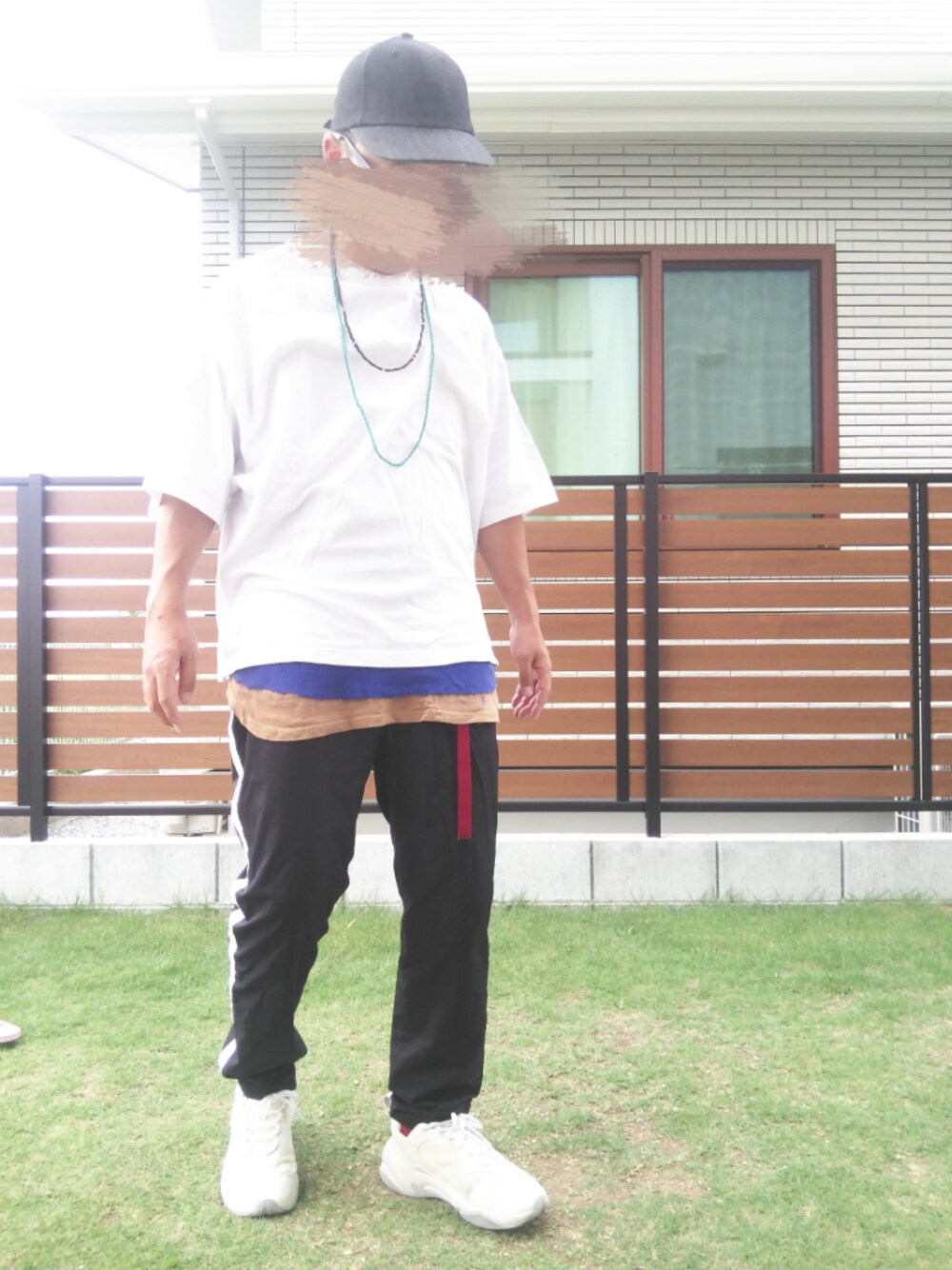 ホワイト系のTシャツ/カットソー、ブラック系のスラックス、イエロー系のタンクトップを着用したメンズの秋コーディネートの1枚目の写真