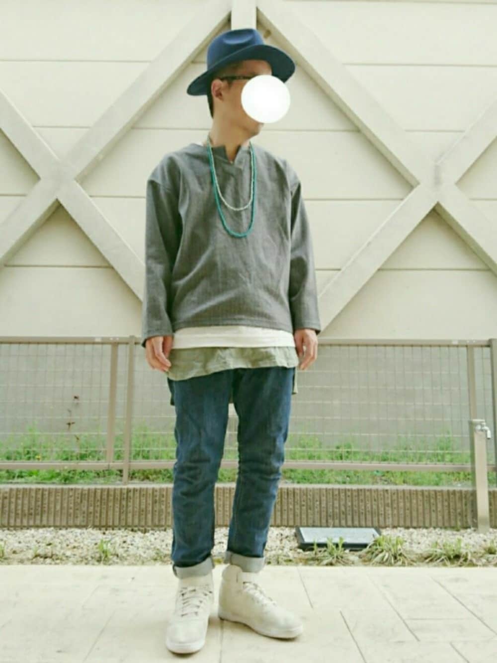 ホワイト系のスニーカー、ブルー系のデニムパンツ、グリーン系のタンクトップを着用したメンズの春コーディネートの1枚目の写真