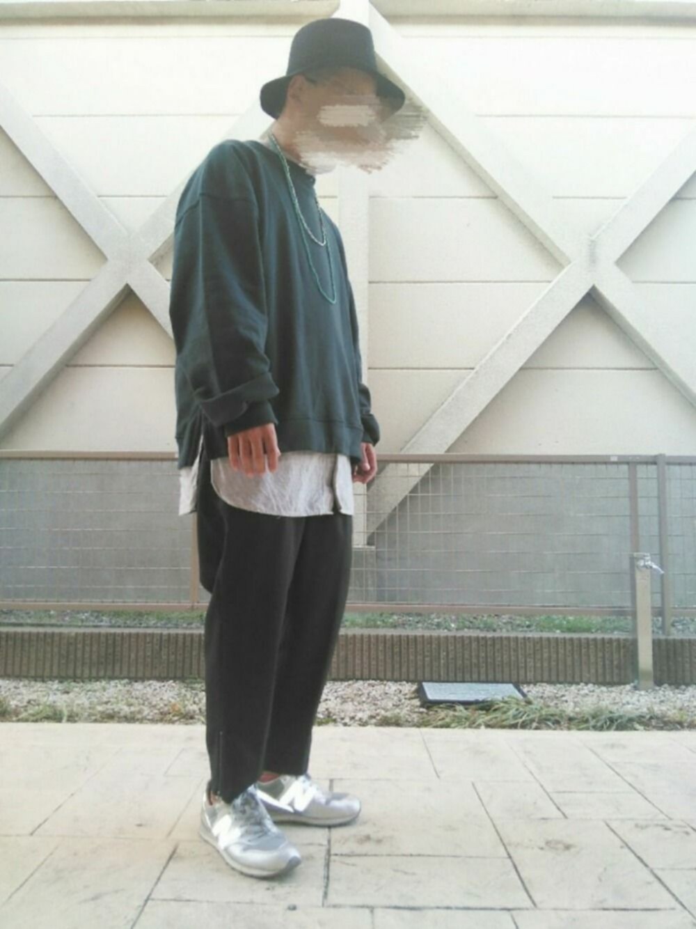 ブラック系のスラックス、シルバー系のスニーカー、ブラック系のハットを着用したメンズの秋コーディネートの1枚目の写真