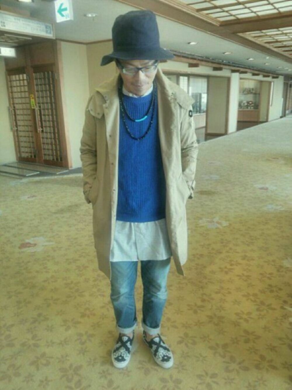 ブラック系のスニーカー、ブルー系のニット/セーター、ブルー系のデニムパンツを着用したメンズの冬コーディネートの1枚目の写真