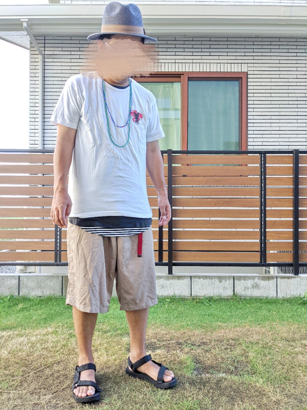 ブラウン系のその他パンツ、ブラック系のサンダル、ホワイト系のTシャツ/カットソーを着用したメンズの秋コーディネートの1枚目の写真