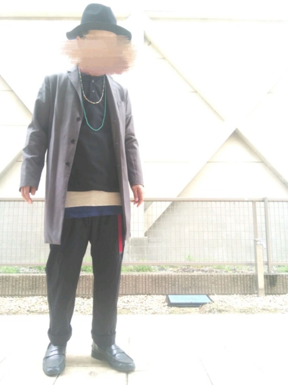 グレー系のチェスターコート、ブルー系のタンクトップ、ブラック系のシャツ/ブラウスを着用したメンズの春コーディネートの1枚目の写真