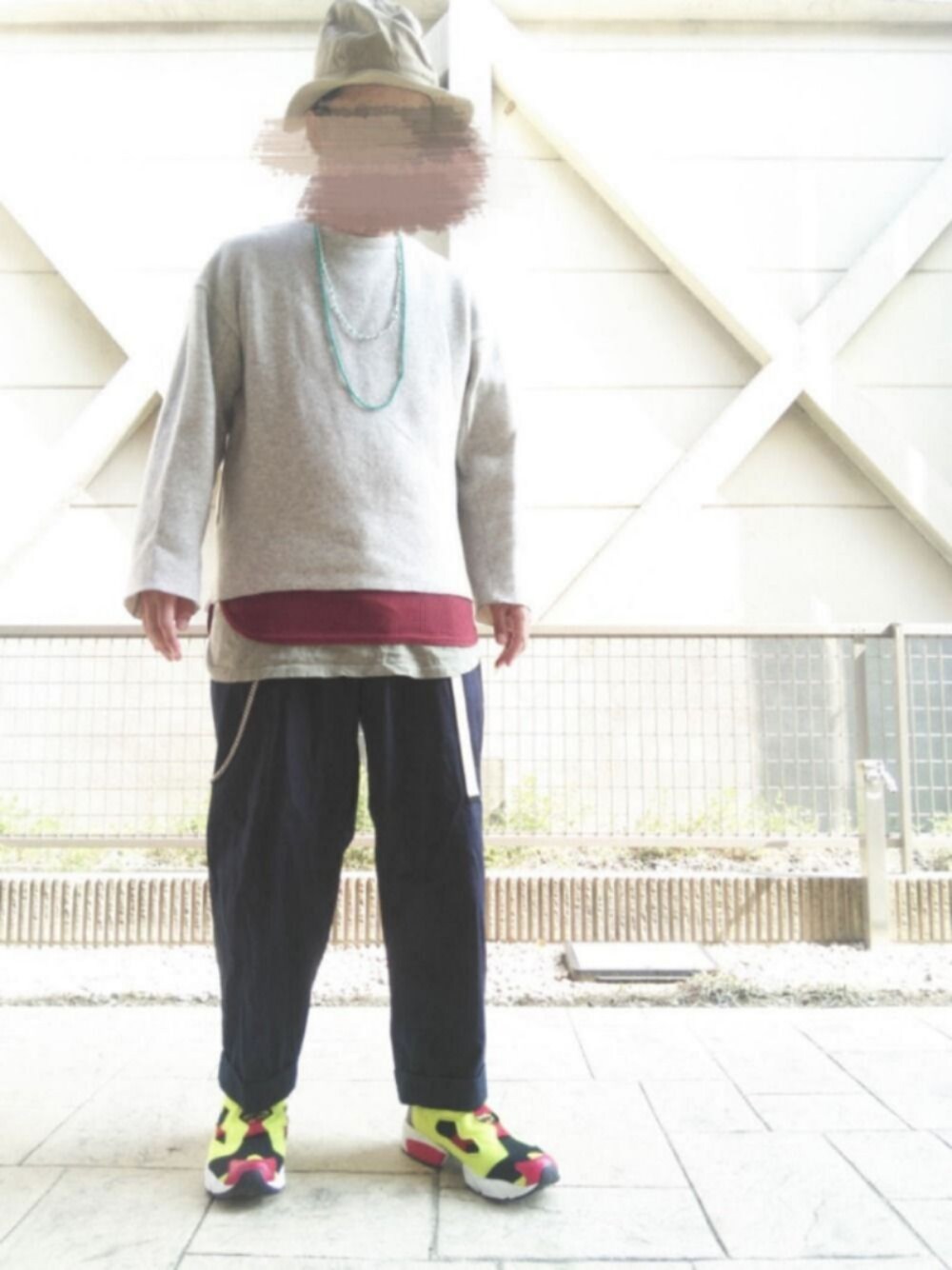 ブラック系のスニーカー、グリーン系のタンクトップ、ベージュ系のハットを着用したメンズの春コーディネートの1枚目の写真