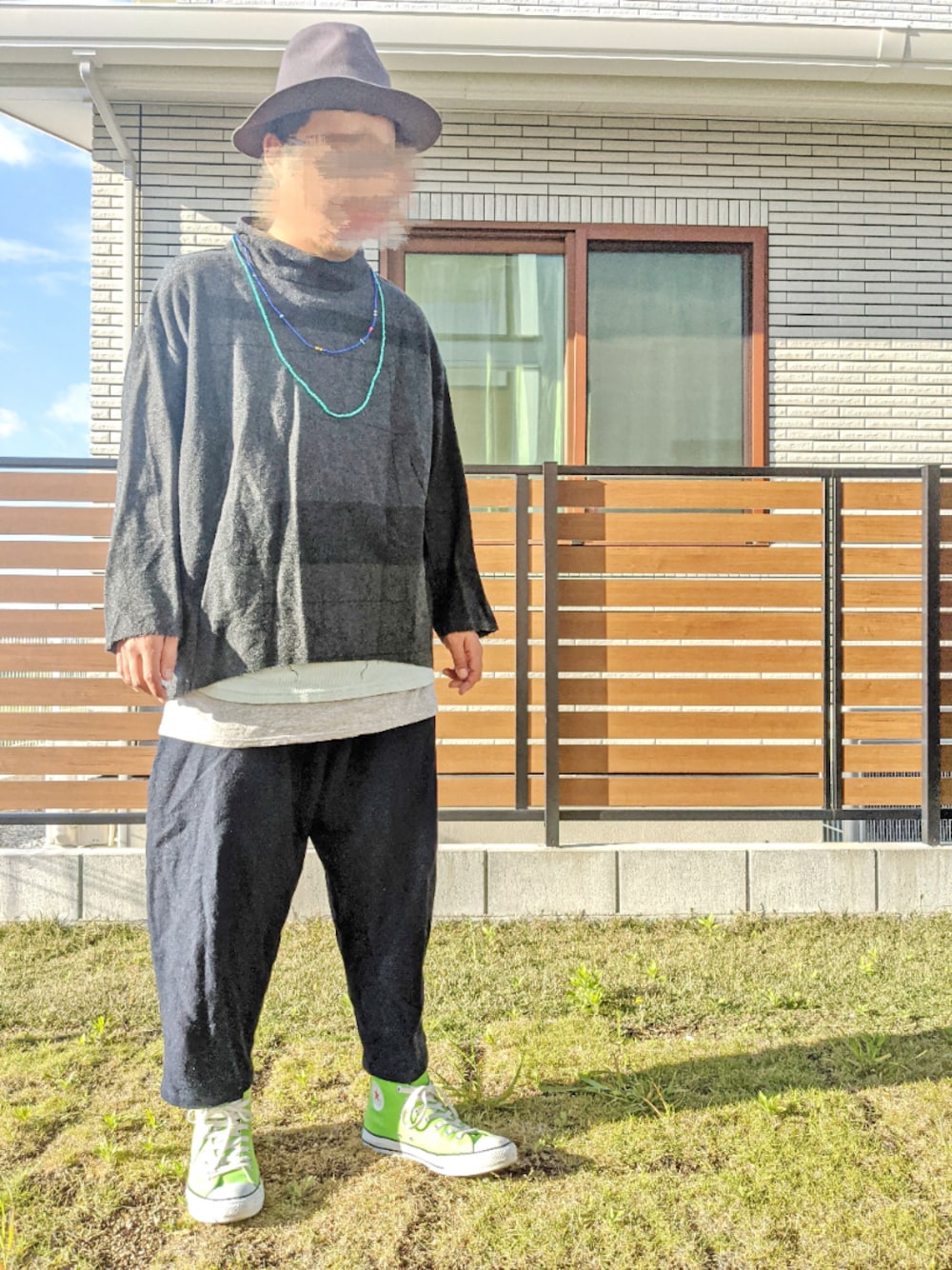 グレー系のニット/セーター、ブルー系のTシャツ/カットソー、グレー系のタンクトップを着用したメンズの春コーディネートの1枚目の写真