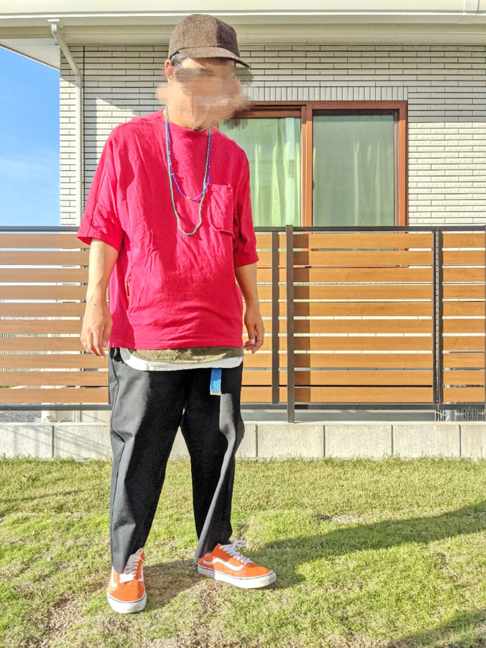 レッド系のTシャツ/カットソー、オレンジ系のスニーカー、ブラック系のチノパンツを着用したメンズの春コーディネートの1枚目の写真