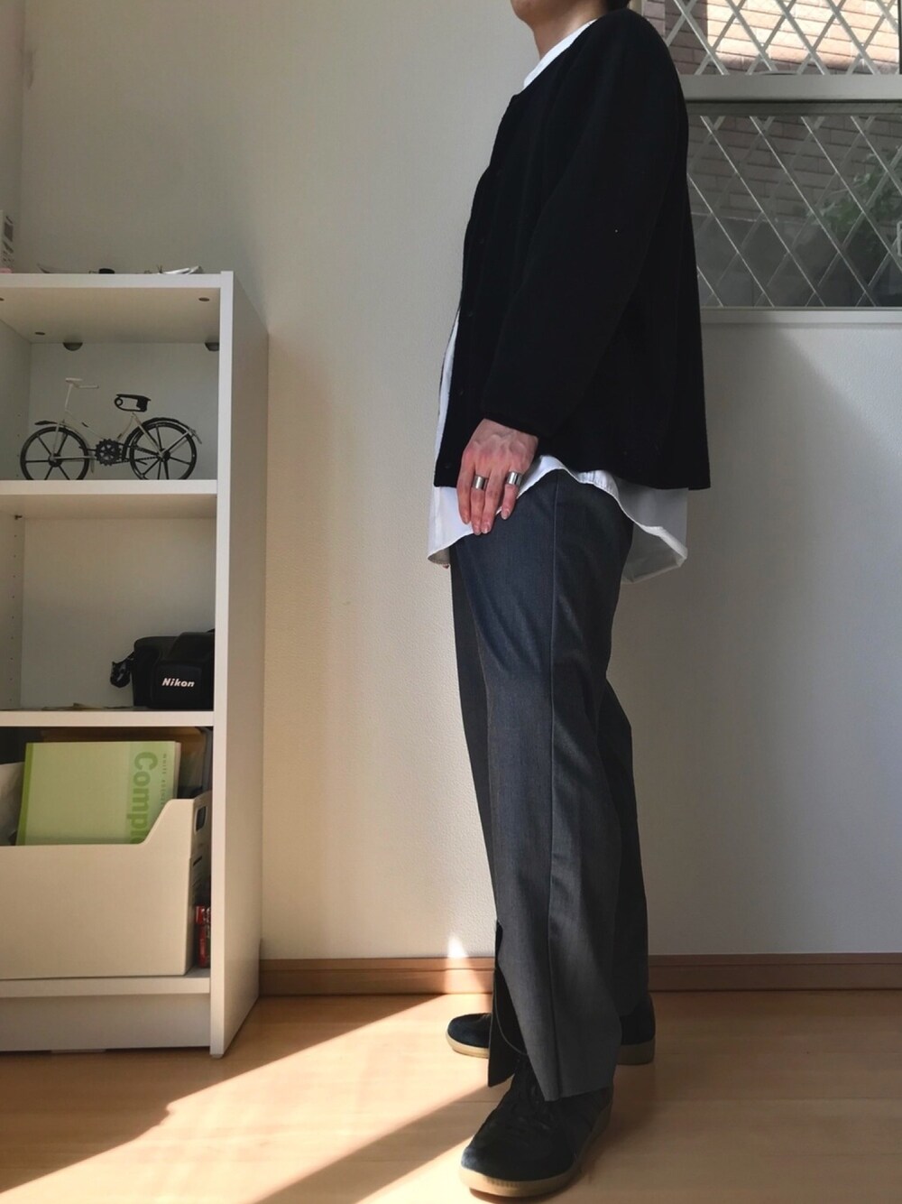 ブラック系のカーディガン/ボレロ、ホワイト系のシャツ/ブラウス、グレー系のスラックスを着用したメンズの春コーディネートの1枚目の写真