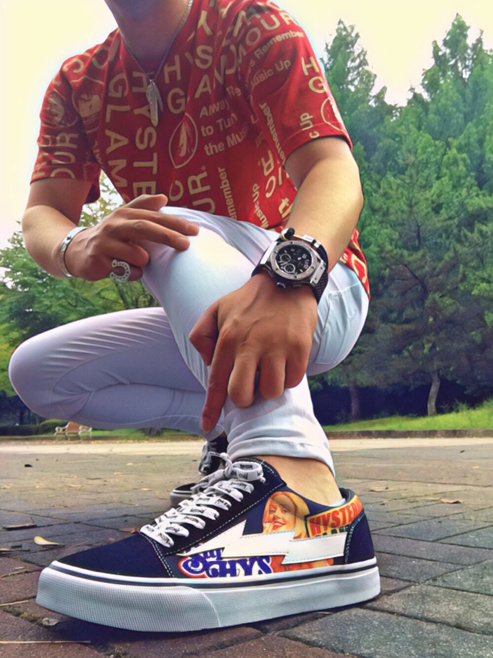 レッド系のTシャツ/カットソー、ホワイト系のデニムパンツ、ブラック系のスニーカーを着用したメンズの秋コーディネートの1枚目の写真