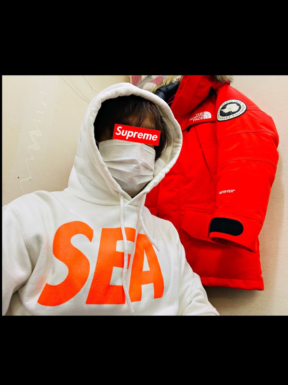 レッド系のダウンジャケット/コート、ホワイト系のパーカーを着用したメンズの冬コーディネートの1枚目の写真