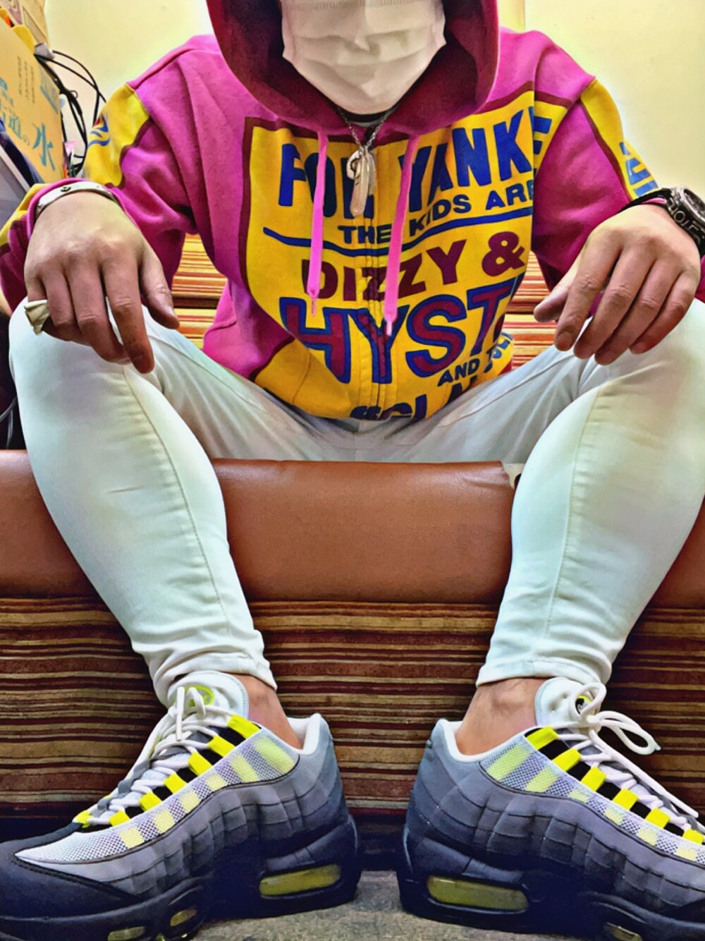 ピンク系のパーカー、グレー系のスニーカー、ホワイト系のデニムパンツを着用したメンズの冬コーディネートの1枚目の写真