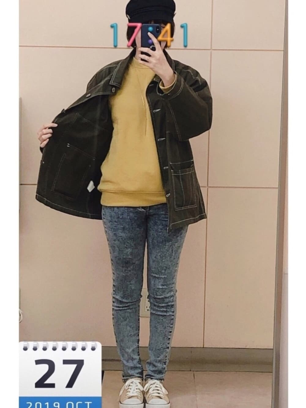 ブルー系のデニムパンツ、グリーン系のミリタリージャケット、イエロー系のその他トップスを着用したレディースの秋コーディネートの1枚目の写真